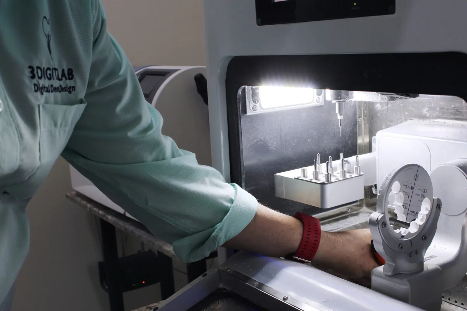 Técnico cargando herramientas en la fresadora CAD/CAM del laboratorio